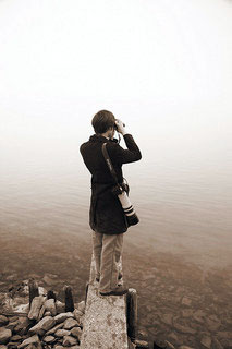 Man looking over lake with binoculars | Find online school