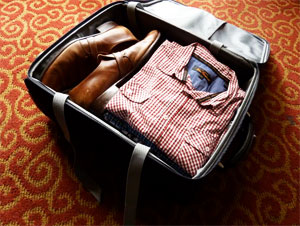 Study tips for traveling for online students - open luggage with clothes