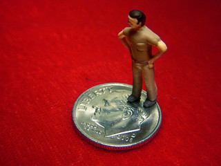 Online college course cost, figurine standing one a dime