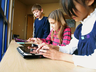 Technology in the classroom: students playing with an ipad