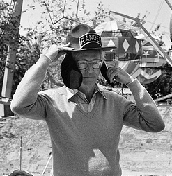 Black and white photo of Charles Schulz wearing a Snoopy hat