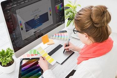 An online graphic design degree graduate at work