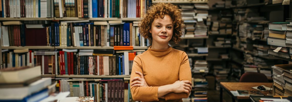 Graduates of ALA accredited online MLIS programs find themselves working in libraries like this young women