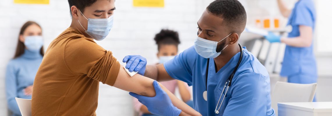 Covid-19 Vaccination. Asian Male Patient Getting Vaccinated Against Coronavirus Receiving Covid Vaccine Intramuscular Injection During Doctor's Appointment In Hospital. Corona Virus Immunization