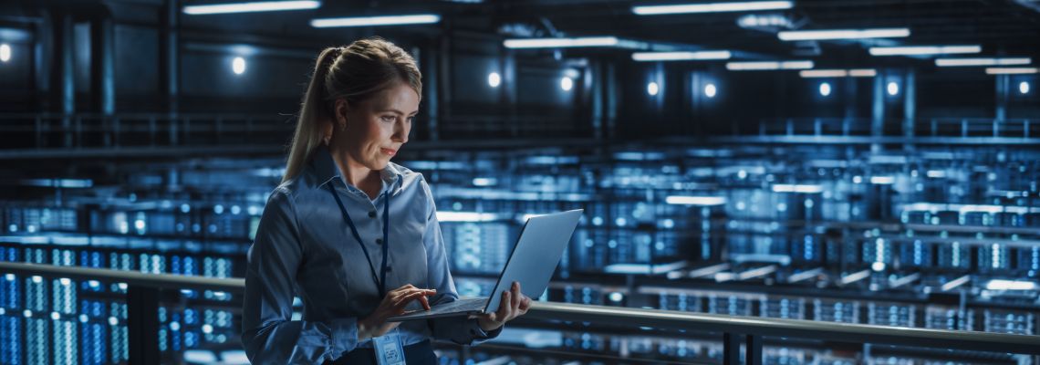 Data Center Female It Specialist Using Laptop. Server Farm Cloud Computing and Cyber Security Maintenance Administrator Working on Computer. Information Technology Professional.