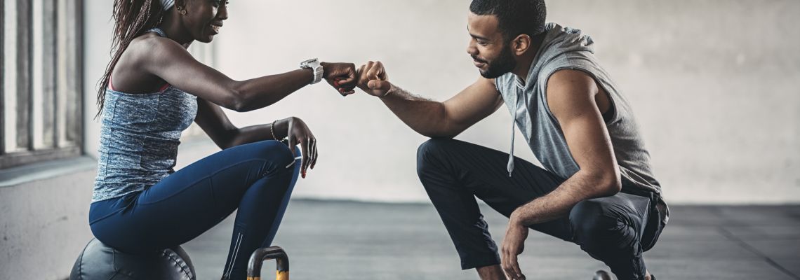 Trainer and female client talking in gym