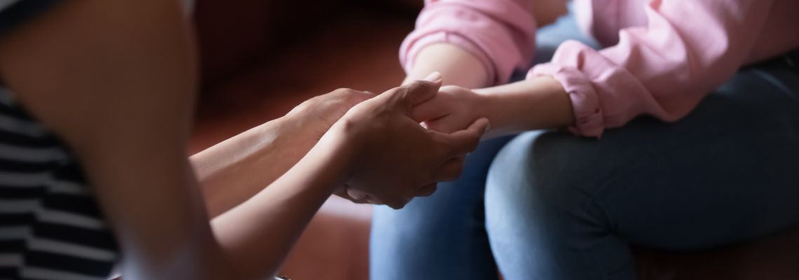 African psychologist, graduate of APA accredited online PhD psychology, holds hands of girl patient