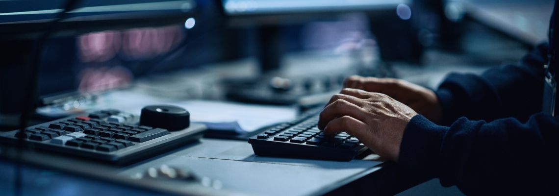 Close Up of a Professional Office Specialist Working on Desktop Computer in Modern Technological Monitoring Control Room with Digital Screens. Manager Typing on keyboard and Using Mouse.