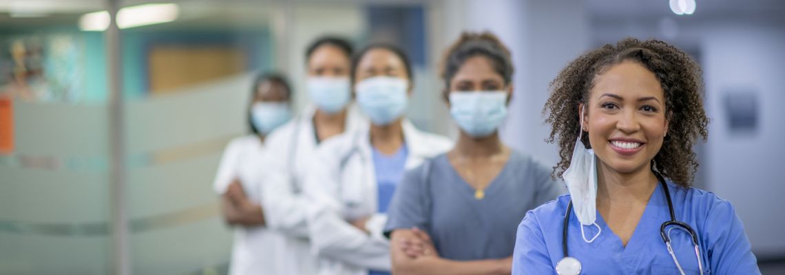 A diverse group of woman doctors and nurses stand confidently in a medical facility,