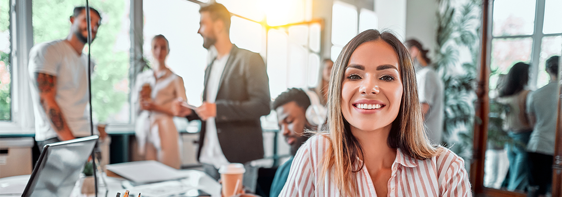 HR Consultant sits at desk in busy office