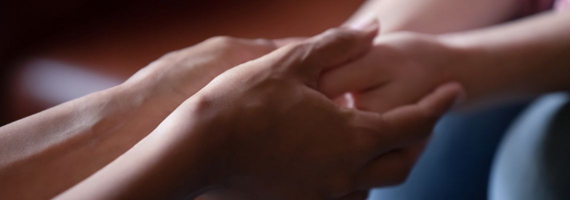Rehabilitation counselor holds the hands of a patient.