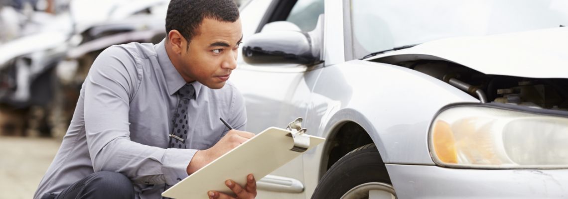 Claims adjuster inspects a damaged car.