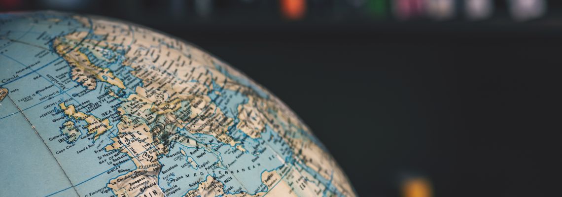 Close up on desktop globe. Europe and Northern Africa. In background out of focus books on shelves A globe in a library representing Online MBA Europe