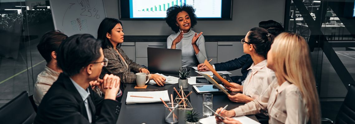 Young confident successful business people discuss and analyze work, statistics, plans, startup in a meeting room. Teamwork. Presentation. Masters in Leadership graduate leads a business meeting.