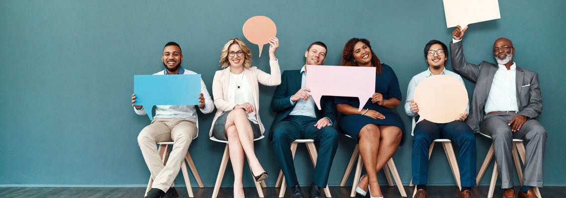 Group of people hold speech bubbles symbolizing their online communications degree