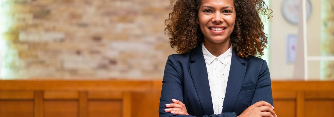How to Become a Hotel Manager, Female manager of a luxury hotel facing camera smiling with arms crossed How to Become a Hotel Manager