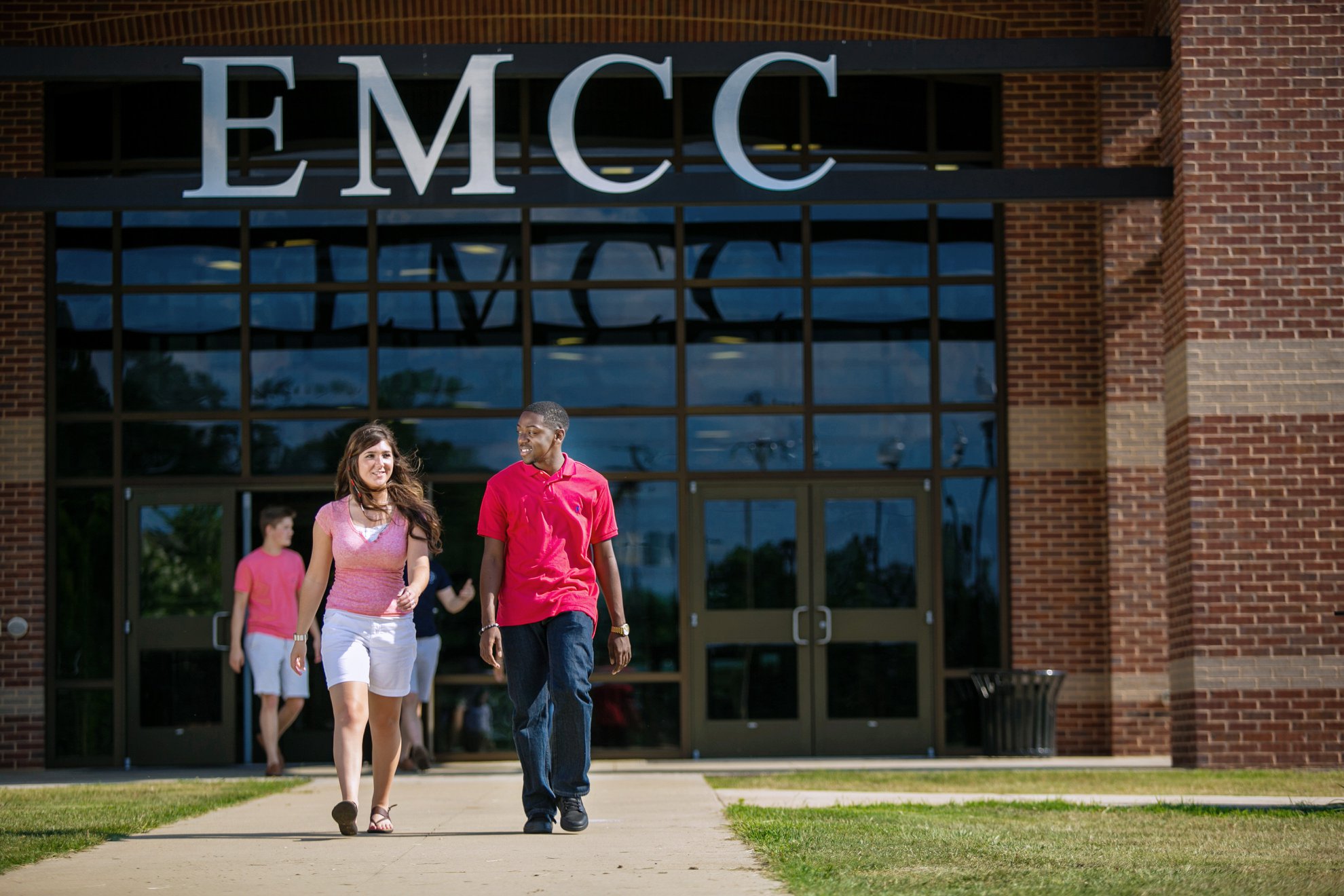Students walking outside East Mississippi Community College beneath the EMCC building sign