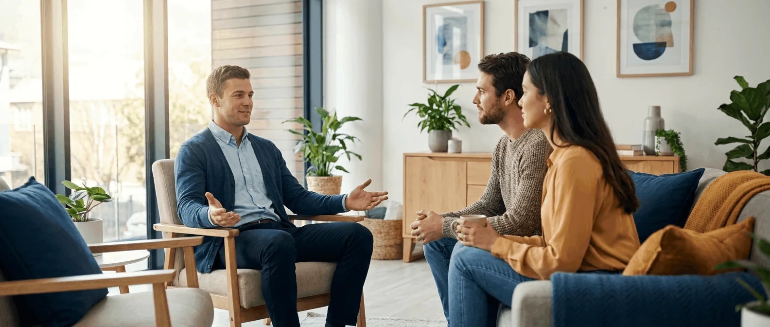 Marriage and family therapist counseling a couple in a warm, modern office.
