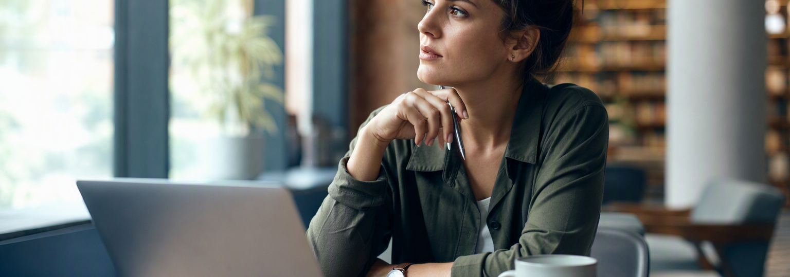 Adults discussing education options in a modern classroom environment for online AI master's degree