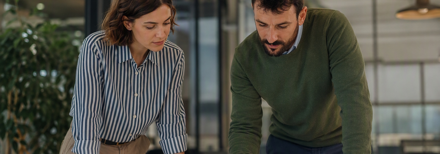Two professionals discussing project management strategies in a collaborative office setting